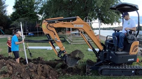 mini excavator trenching across a slope|digging deep trenches with mini excavators.